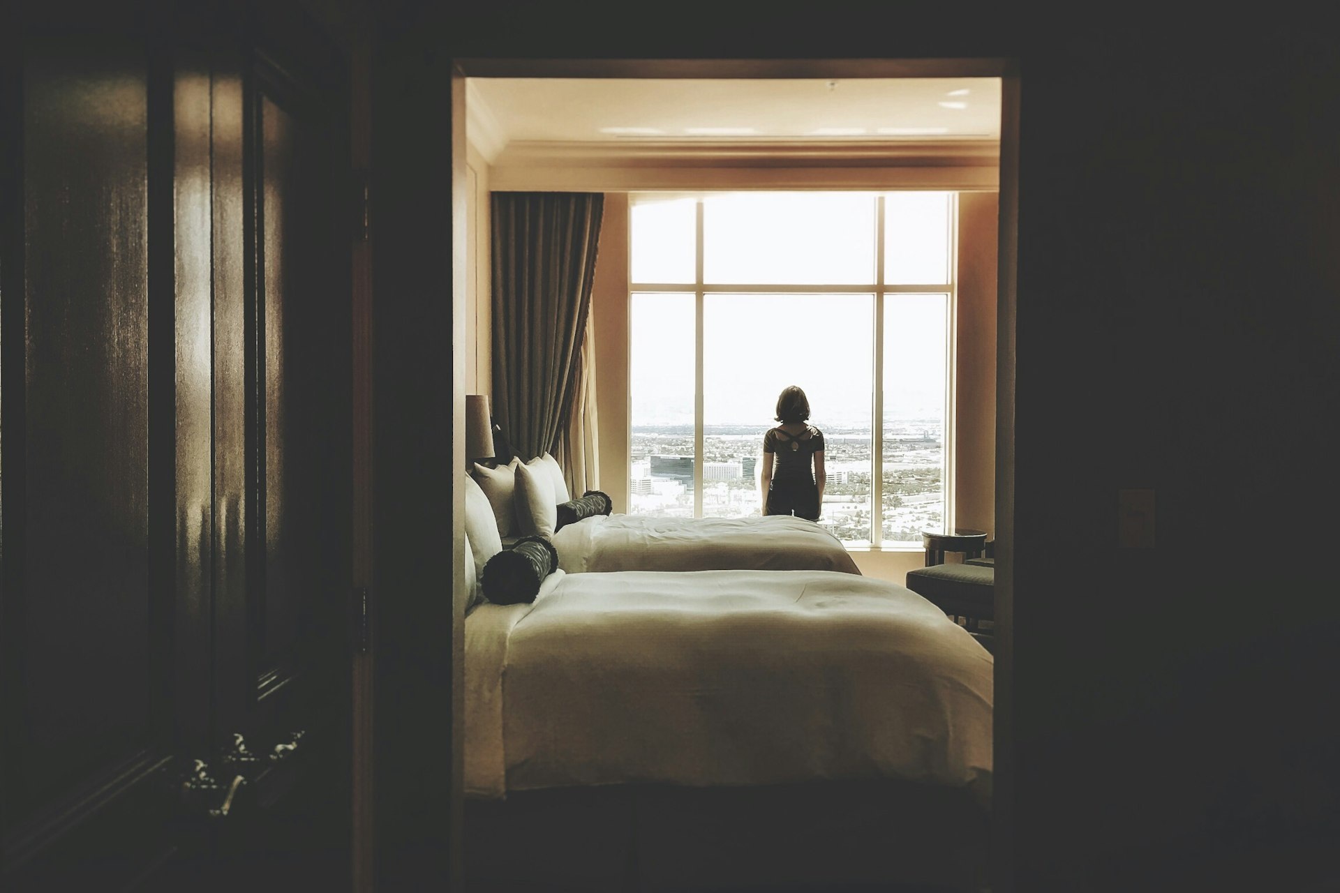 Hotelzimmer mit großem Fenster und Gast am Fenster