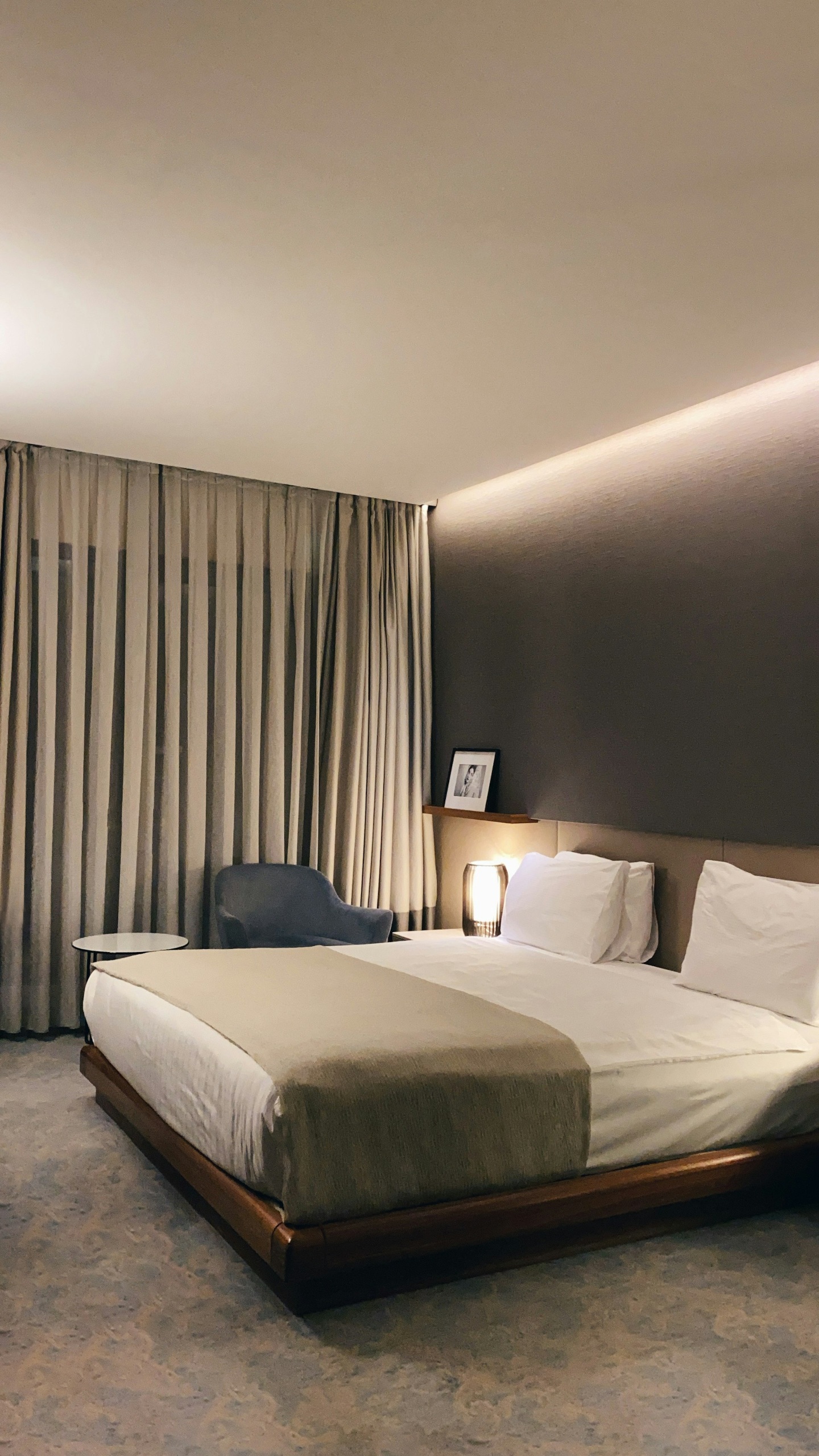 Modernes Hotelzimmer mit Doppelbett und grauen Vorhängen